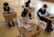 Group of diverse students studying in a well-lit indoor classroom setting.