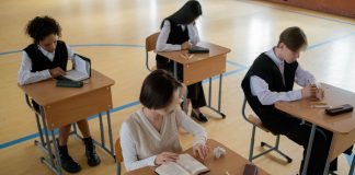Group of diverse students studying in a well-lit indoor classroom setting.