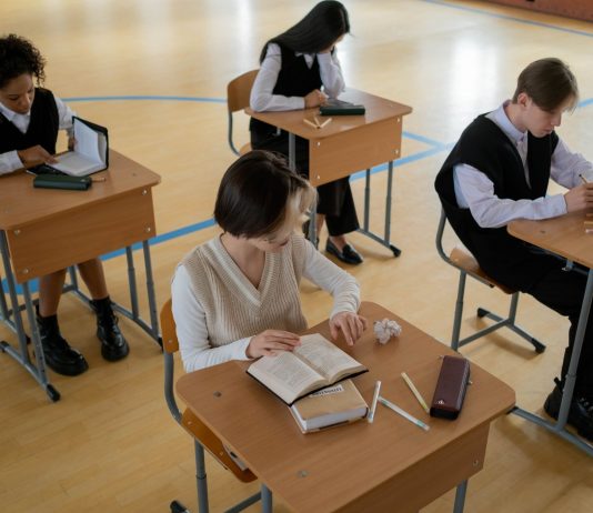 Group of diverse students studying in a well-lit indoor classroom setting.