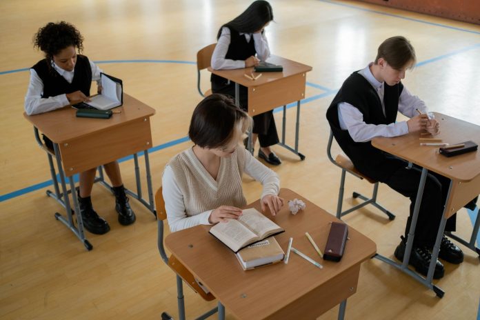 best-private-schools-near-west-new-york-nj Group of diverse students studying in a well-lit indoor classroom setting.
