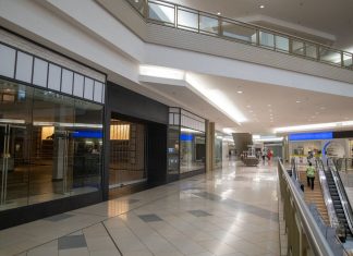 Spacious and contemporary mall interior with closed stores and escalator.