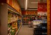 Colorful drink aisle in a supermarket with signage promoting deals.