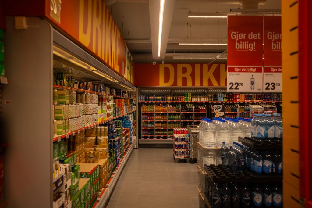 Colorful drink aisle in a supermarket with signage promoting deals.