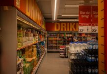 Colorful drink aisle in a supermarket with signage promoting deals.