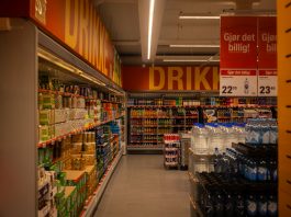 Colorful drink aisle in a supermarket with signage promoting deals.
