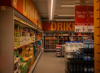 Colorful drink aisle in a supermarket with signage promoting deals.