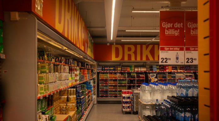 Colorful drink aisle in a supermarket with signage promoting deals.
