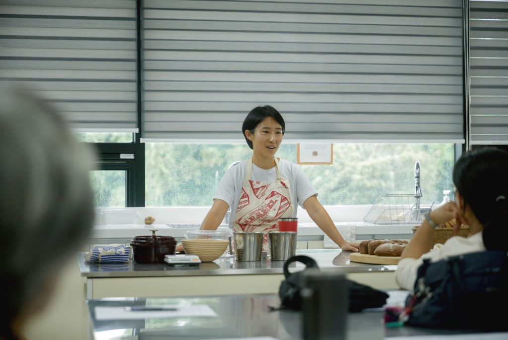 Chef leading a cooking class, explaining techniques to students in a bright, modern kitchen.