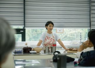 Chef leading a cooking class, explaining techniques to students in a bright, modern kitchen.
