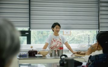 Chef leading a cooking class, explaining techniques to students in a bright, modern kitchen.