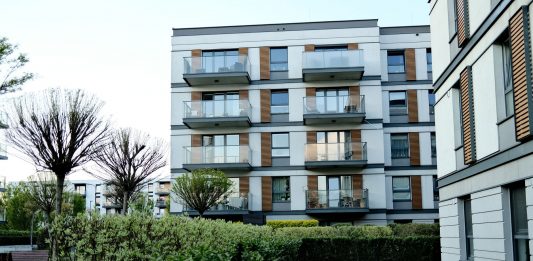 BREAKING: 132-Unit Ridge Pointe Complex Sold in Fort Lee Contemporary apartment complex with balconies and lush garden in urban setting.