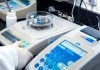 Close-up of laboratory equipment with capsules, capturing pharmaceutical analysis.