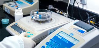 Close-up of laboratory equipment with capsules, capturing pharmaceutical analysis.