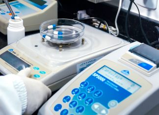 Close-up of laboratory equipment with capsules, capturing pharmaceutical analysis.