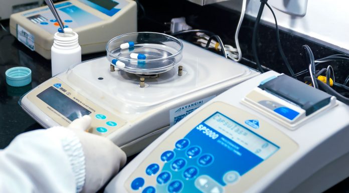 Close-up of laboratory equipment with capsules, capturing pharmaceutical analysis.