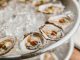 Close-up of fresh oysters served on a bed of crushed ice, perfect for seafood lovers.