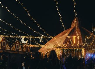 BREAKING: Fall 2026 Festival Guide for Hoboken, Jersey City A vibrant evening market scene under string lights with people gathering in a lively atmosphere.