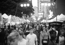 Bustling street market with diverse crowd in black and white.