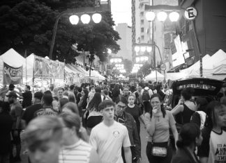 Bustling street market with diverse crowd in black and white.