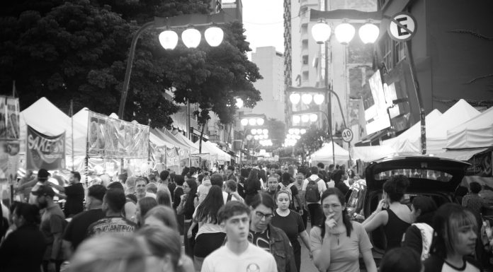 Bustling street market with diverse crowd in black and white.
