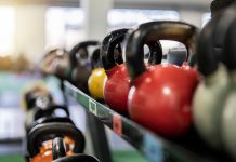 Close-up of colorful kettlebells on a rack in a modern gym indoors.