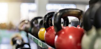 Close-up of colorful kettlebells on a rack in a modern gym indoors.