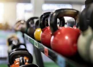 Close-up of colorful kettlebells on a rack in a modern gym indoors.