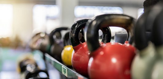 BREAKING: FIT Lab Marks Decade of Personalized Training in Hoboken Close-up of colorful kettlebells on a rack in a modern gym indoors.