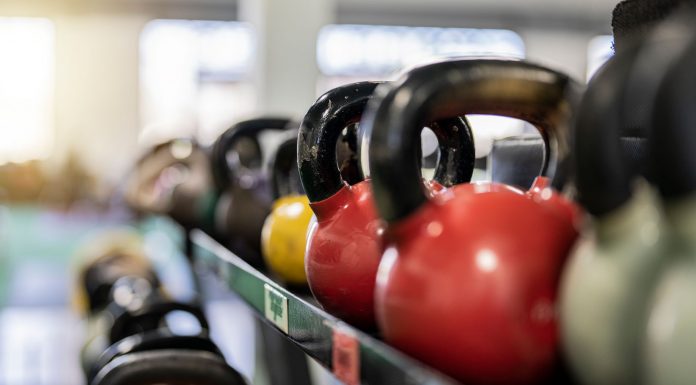 Close-up of colorful kettlebells on a rack in a modern gym indoors.