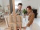 Man and woman collaborating on a painting in a bright art studio with an easel.