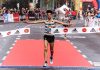 A triumphant marathon winner crosses the finish line, embodying athletic success.