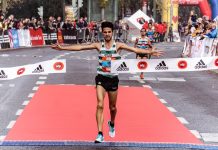 A triumphant marathon winner crosses the finish line, embodying athletic success.