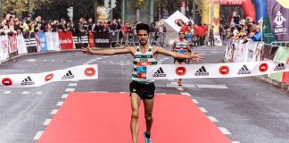 A triumphant marathon winner crosses the finish line, embodying athletic success.