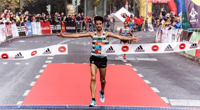 A triumphant marathon winner crosses the finish line, embodying athletic success.