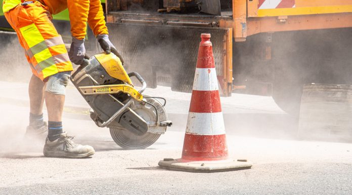 BREAKING: Hudson County Starts Major JFK Boulevard Safety Overhaul Monday A construction worker cutting asphalt with a large saw next to a traffic cone on a street.