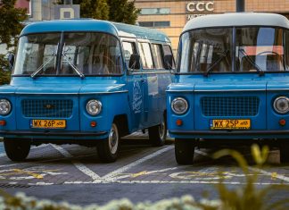 BREAKING: Jersey City Library Announces Bookmobile Hours at Five Corners Two retro blue vans parked side by side in a city environment, showcasing classic design.