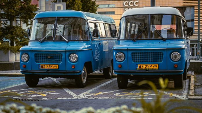 breaking-jersey-city-library-announces-bookmobile- Two retro blue vans parked side by side in a city environment, showcasing classic design.