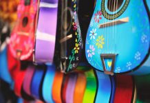 Vibrant close-up of artistically decorated acoustic guitars with floral patterns.