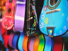Vibrant close-up of artistically decorated acoustic guitars with floral patterns.