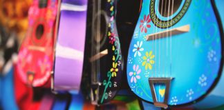 Vibrant close-up of artistically decorated acoustic guitars with floral patterns.