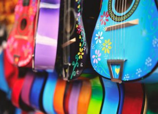 Vibrant close-up of artistically decorated acoustic guitars with floral patterns.