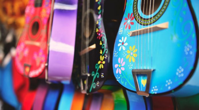 Vibrant close-up of artistically decorated acoustic guitars with floral patterns.