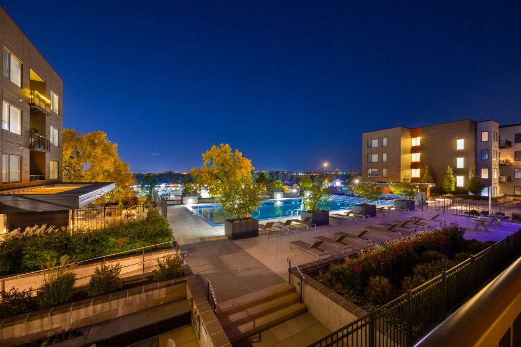 Night view of a luxurious apartment complex with a swimming pool in Westminster, Colorado, USA.