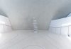 A minimalist and futuristic interior featuring stacked stones and white walls.