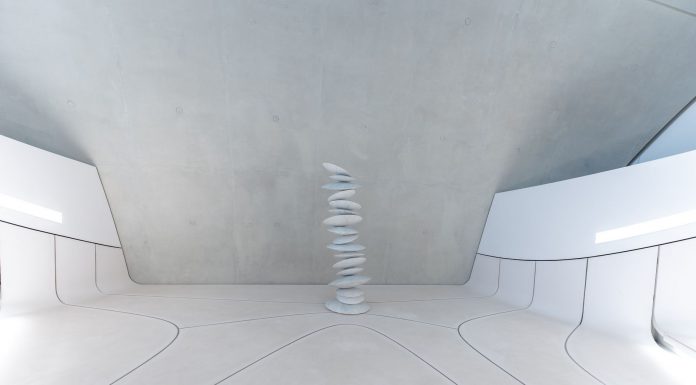 A minimalist and futuristic interior featuring stacked stones and white walls.