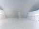 A minimalist and futuristic interior featuring stacked stones and white walls.