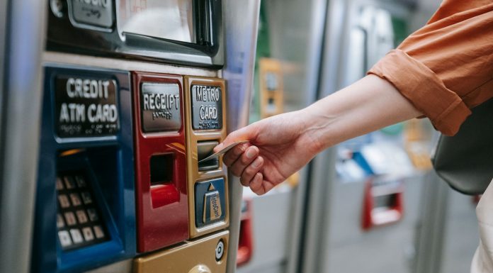 BREAKING: PATH Phases Out SmartLink Cards September 1 Close-up of a person using a metro card machine for public transport payment indoors.