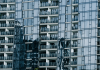 High-rise building with glass facade reflecting surroundings.