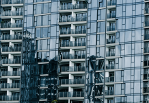 High-rise building with glass facade reflecting surroundings.