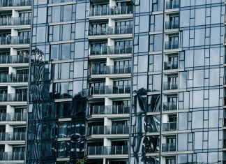 High-rise building with glass facade reflecting surroundings.